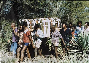 Supporters from run with the cloth-wrapped coffin en route to the cemetery