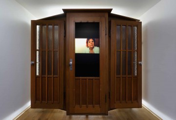 Dimitri Fagbohoun b. 1972, Benin Refrigerium 2014 Wood confessional, broom, book, screws, ceramic objects, electroluminescent paper, frame, inverter, video with sound (5 min. 38 sec.) 210 x 240 x 95 cm (82 5/8 x 94 1/2 x 37 3/8 in.) Collection of the artist