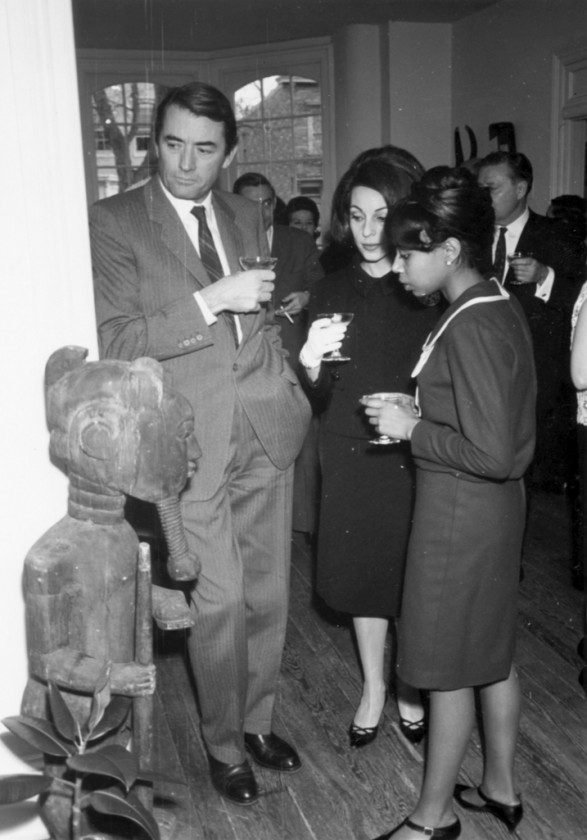 Actor Gregory Peck, Veronique Peck, and unidentified woman admire African art at Museum of African Art