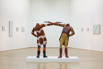 Yinka Shonibare MBE b. 1962, Great Britain How to Blow Up Two Heads at Once (Gentlemen) 2006 Mannequins, guns, Dutch wax printed cotton textile, leather riding boots, plinth 175 x 245 x 122 cm (68 7/8 x 96 1/2 x 48 in.) Sindika Dokolo Collection, Luanda
